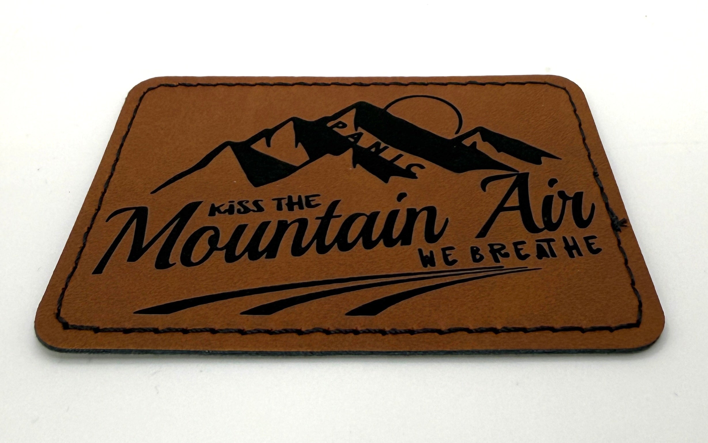 Kiss The Mountain Air Patch 3.5” x 2.5” | Laser Engraved | Rawhide/Black | Iron or stitch | Panic Fan Art